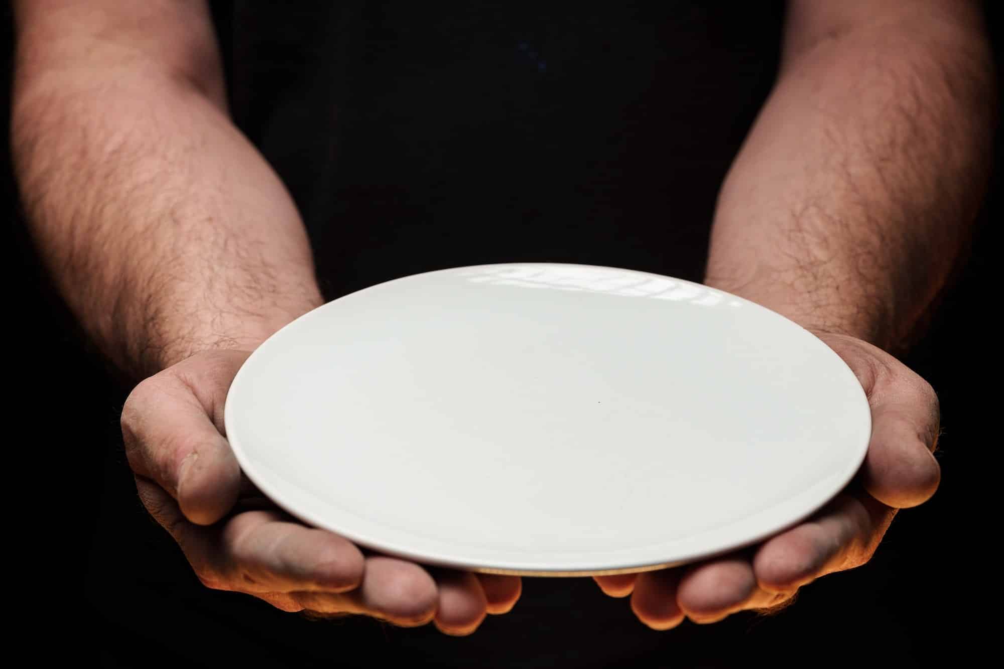 Mann holder tomt hvitt fat